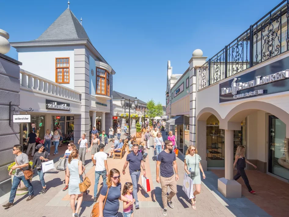 Einkaufsstraße im Designer Outlet Roermond bei Sonnenschein